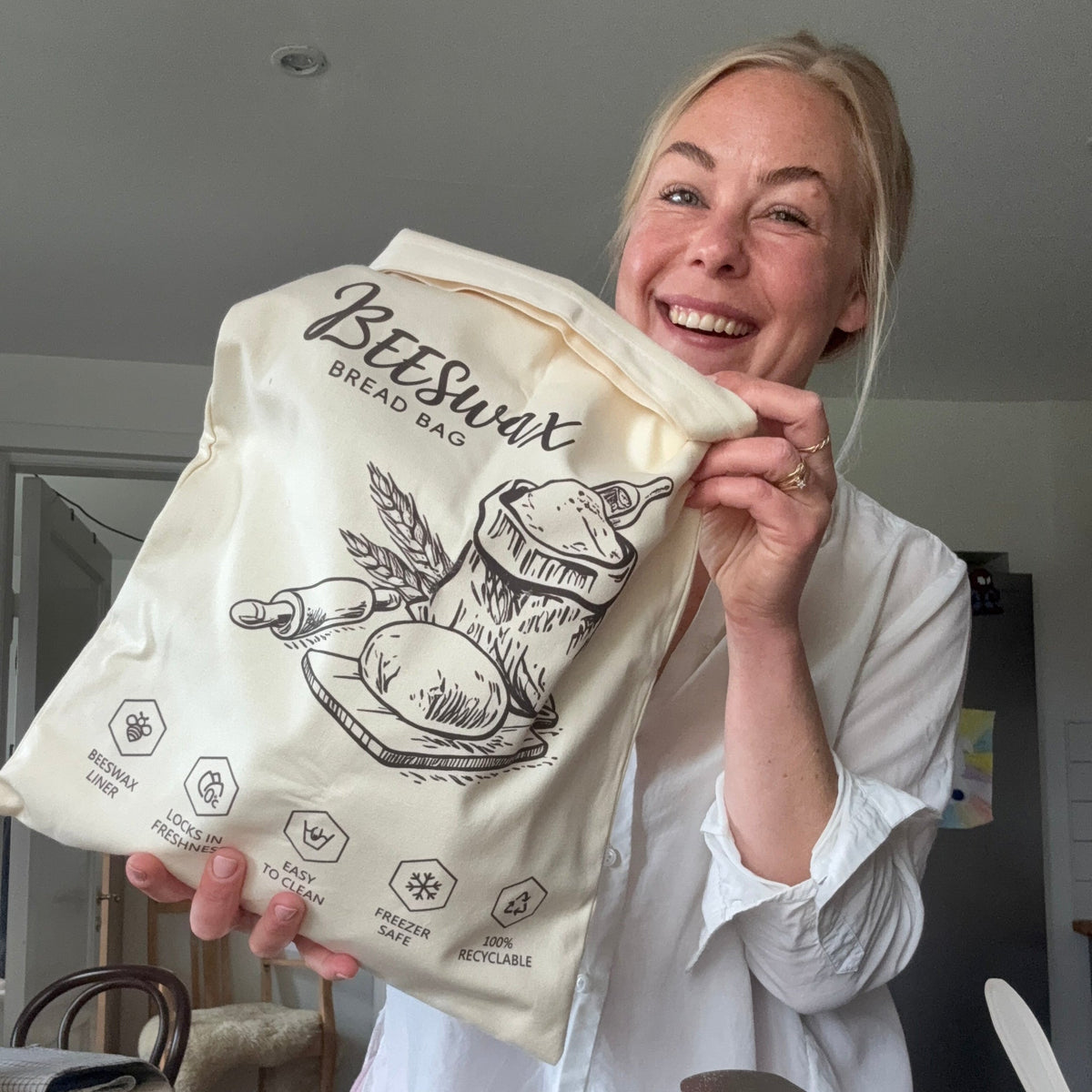 Beeswax bread bag in Sand Beige, held up by a smiling customer